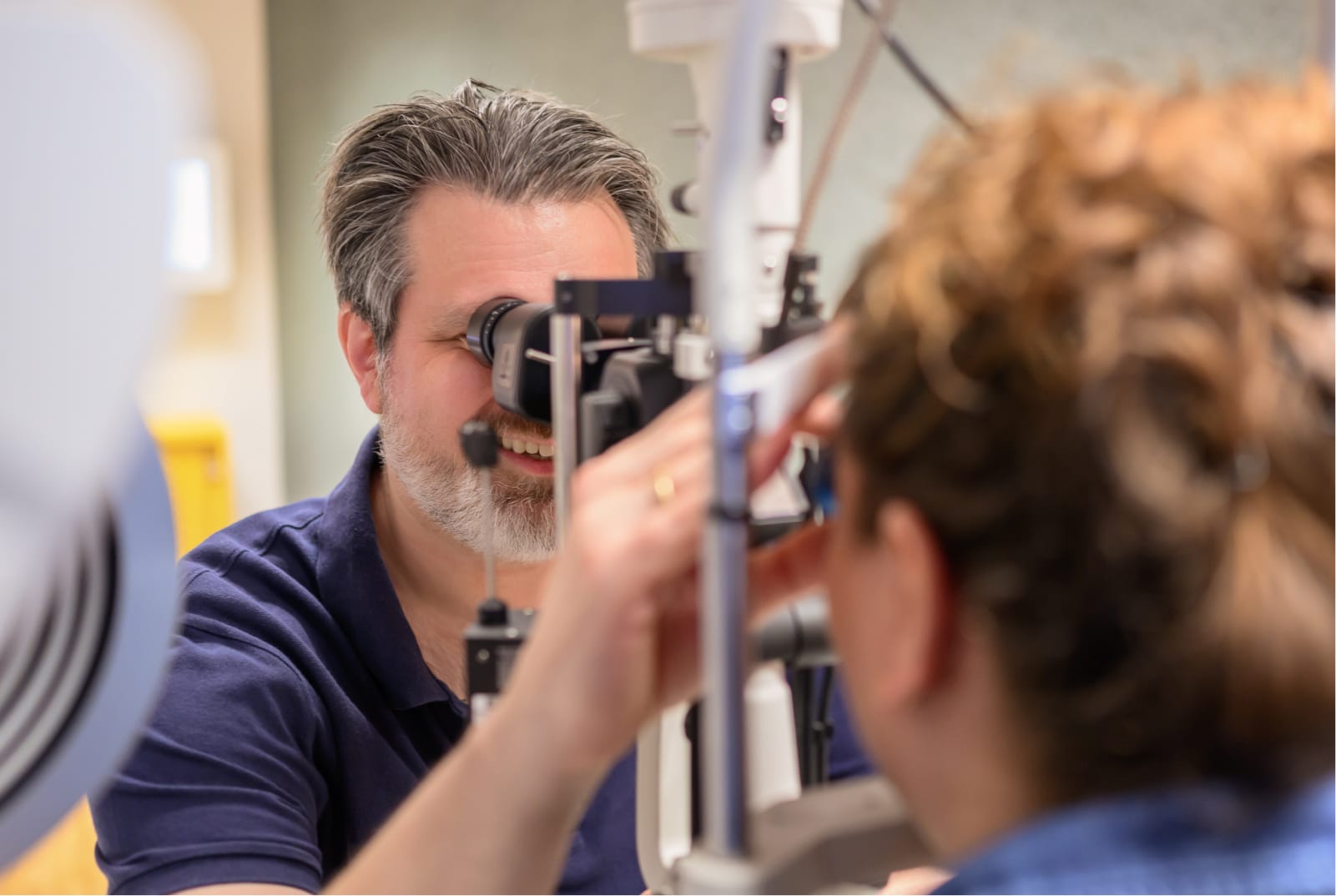 Nahaufnahme von Augenarzt Prof. Dr. med. Michael Böhm, wie er die Augen einer Patientin untersucht